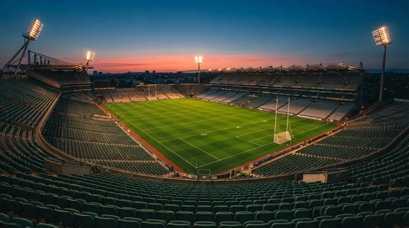 An empty football stadium with floodlight masts at dusk