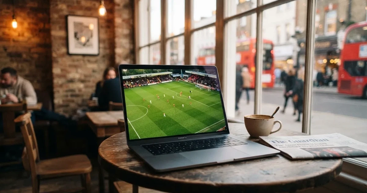 A laptop on a café table by a window onto the street