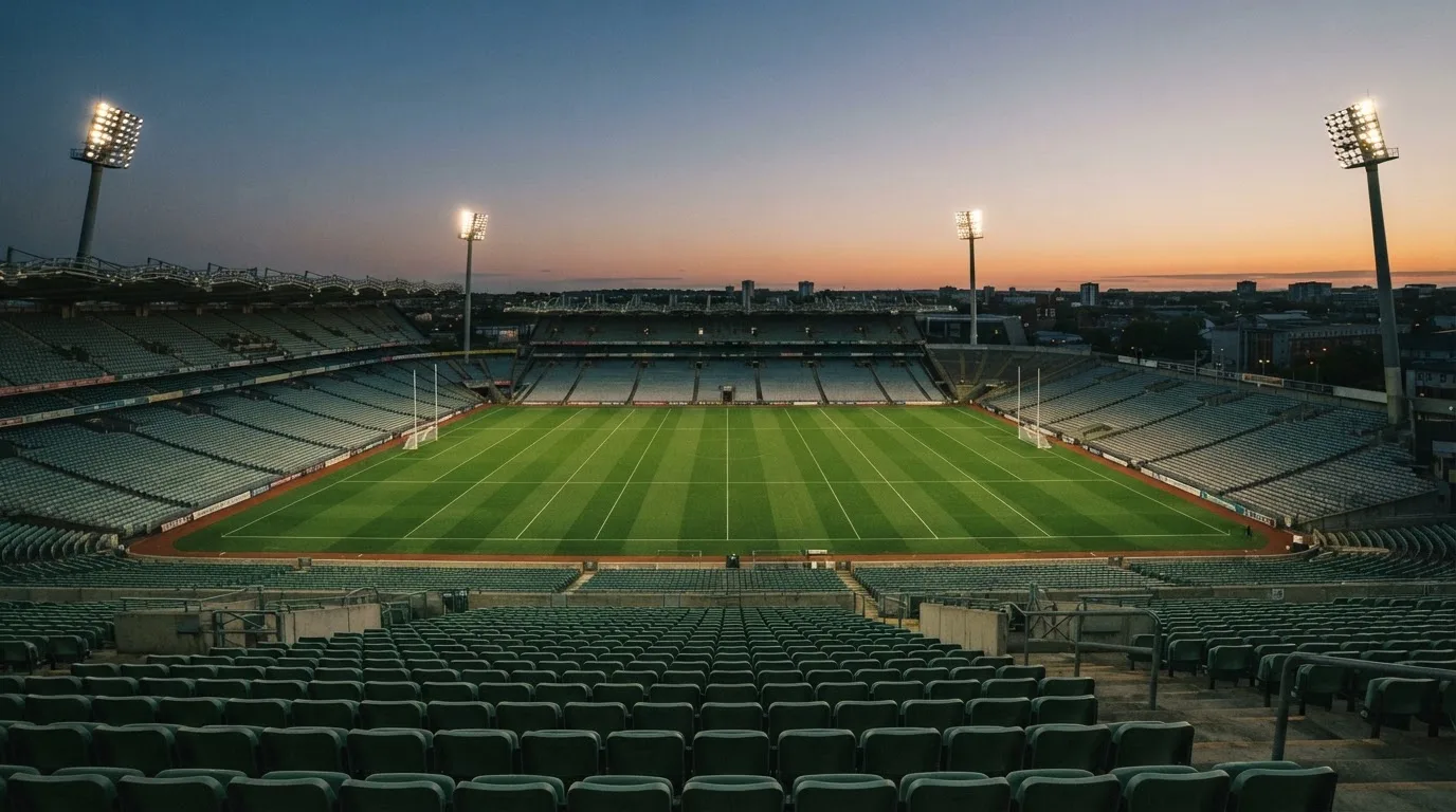 An empty football stadium with floodlight masts at dusk
